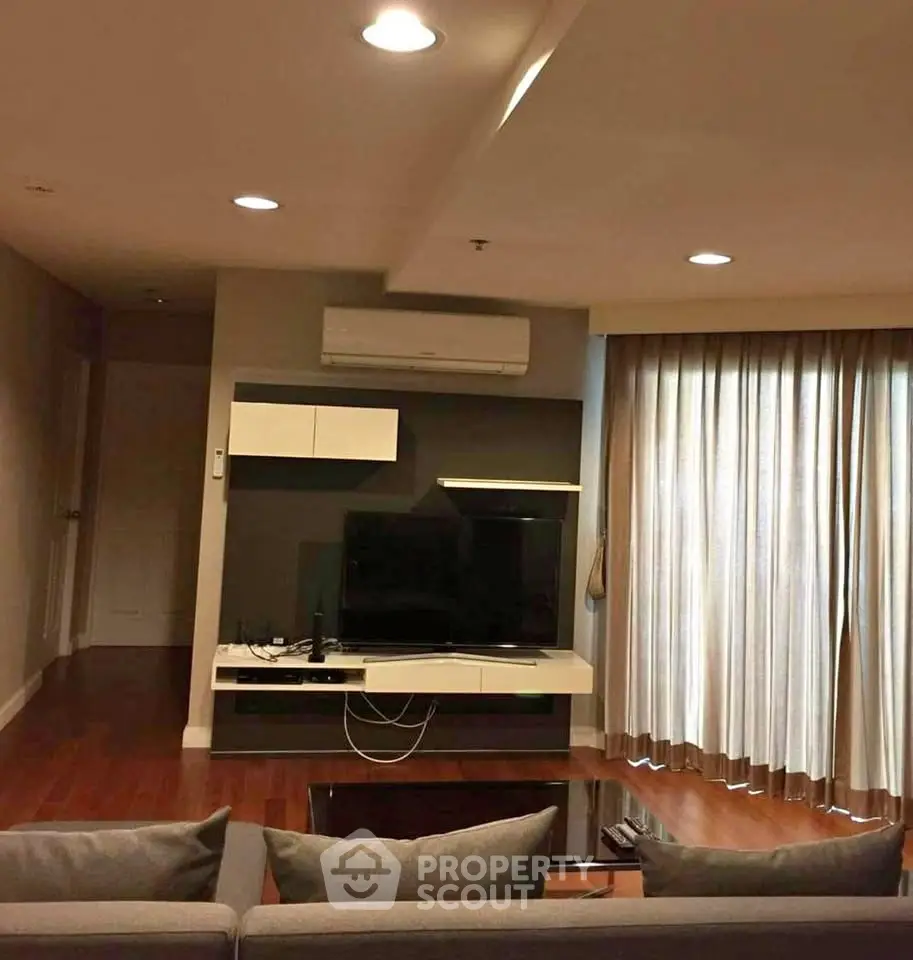 Modern living room with sleek furniture and large TV, perfect for relaxation and entertainment.