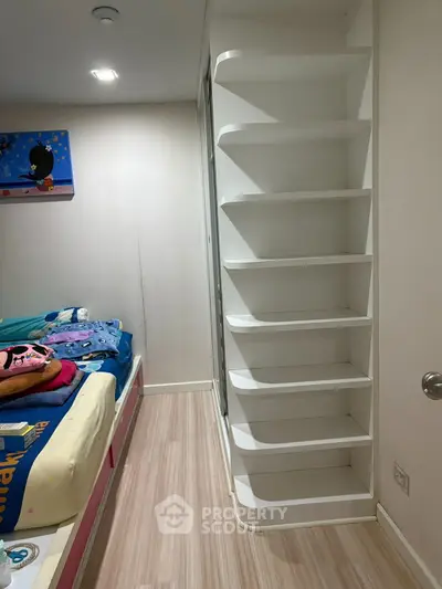 Cozy children's bedroom with built-in shelving and colorful bedding, perfect for a playful and organized space.