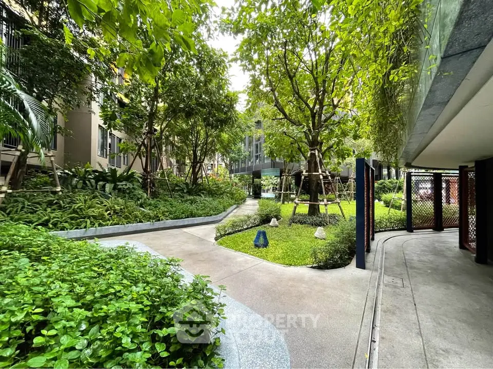 Lush garden pathway in modern residential complex, perfect for relaxation and outdoor activities.