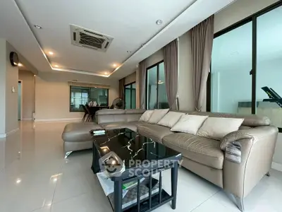 Spacious modern living room with elegant leather sofa and sleek black coffee table, perfect for relaxation.