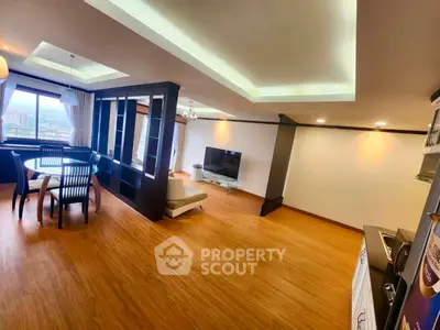 Spacious living room with modern design and large windows offering city views.