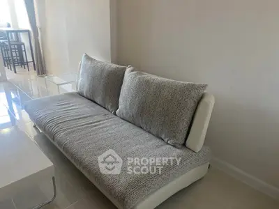 Modern living room with stylish sofa and sleek flooring in a bright apartment.