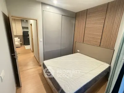 Modern bedroom with sleek design and wooden accents in a contemporary apartment.