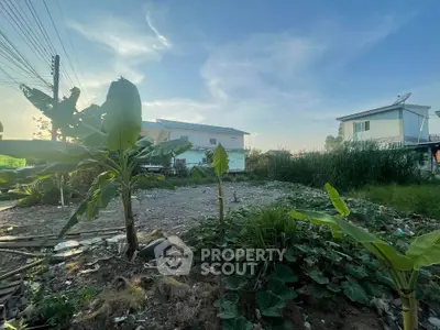 Spacious garden area with lush greenery and residential buildings in the background.