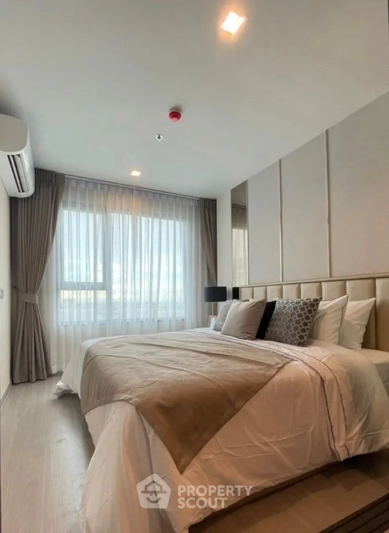 Luxurious bedroom with elegant decor and large window offering natural light.