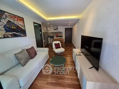 Modern living room with stylish decor and open kitchen layout, featuring a cozy sofa and flat-screen TV.