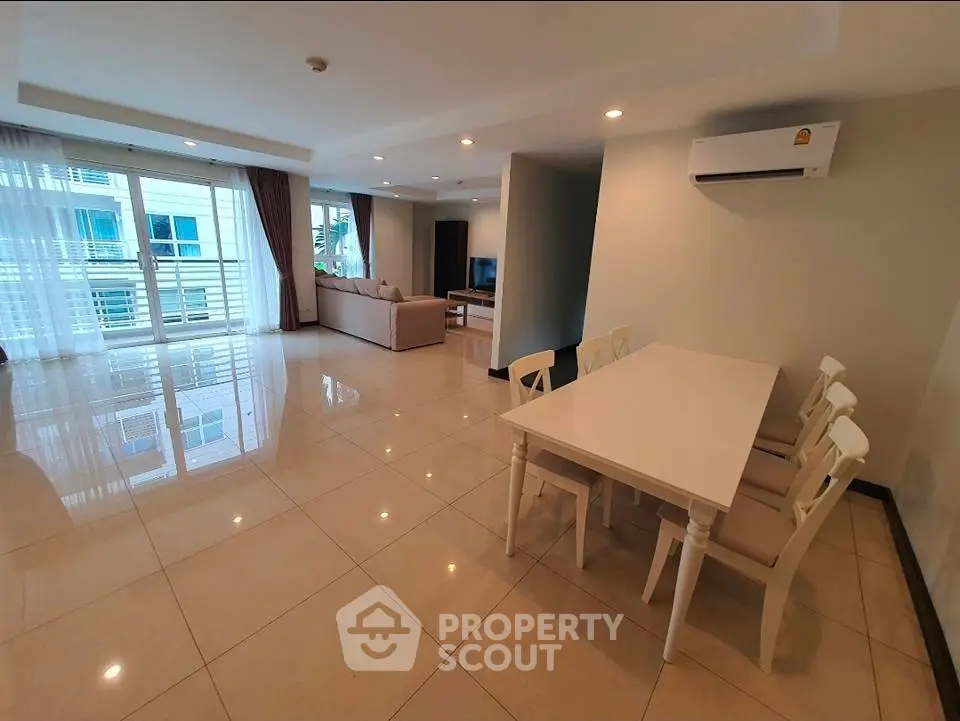 Spacious modern living room with dining area and large windows in a stylish apartment.