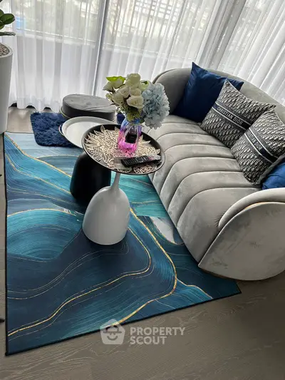 Stylish modern living room with elegant sofa, chic rug, and decorative accents.