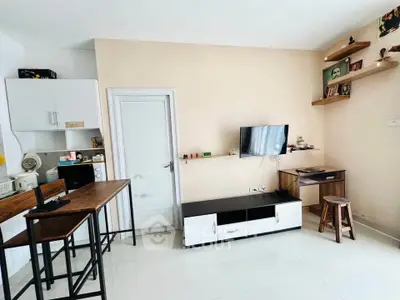 Modern living room with minimalist decor and open kitchen layout, featuring sleek furniture and wall-mounted TV.