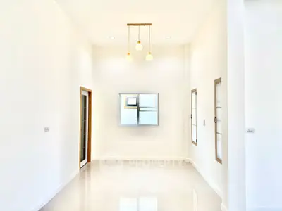 Spacious minimalist room with high ceiling and modern lighting
