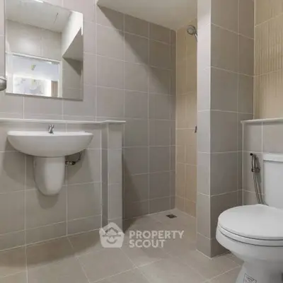 Modern bathroom with sleek tiles and walk-in shower in a contemporary home.