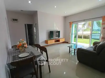 Spacious living room with modern decor and garden view, perfect for relaxation and entertainment.