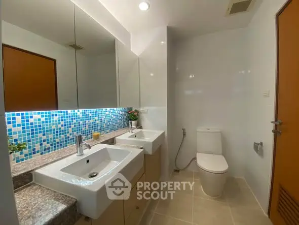 Modern bathroom with dual sinks and stylish mosaic backsplash