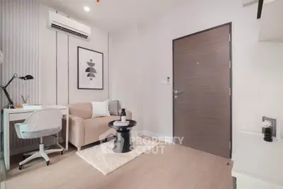 Modern living room with stylish decor and workspace, featuring a cozy sofa and sleek desk.