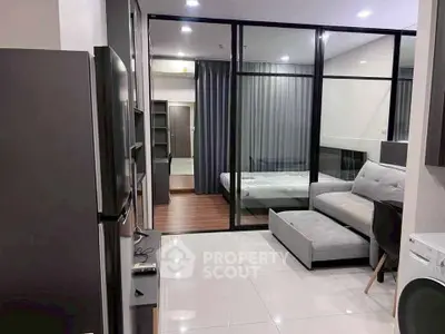 Modern studio apartment with glass partition, cozy living area, and sleek furnishings.