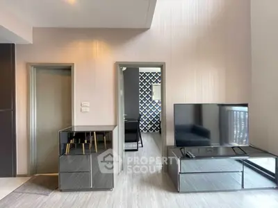 Modern living room with sleek furniture and large TV, showcasing contemporary interior design.