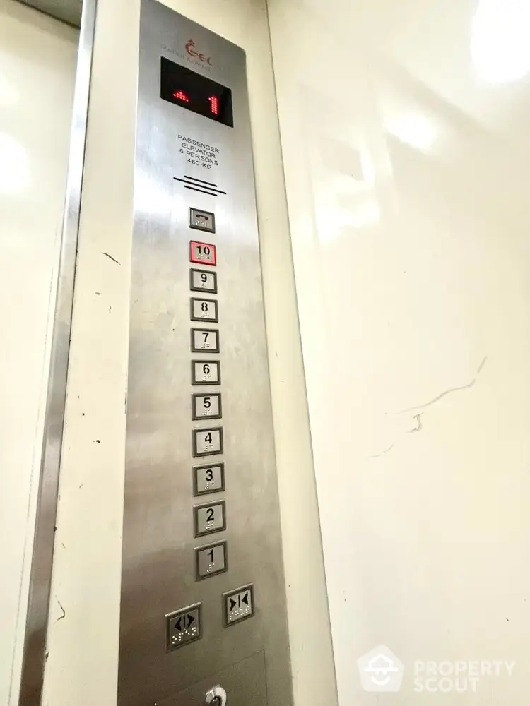 Modern elevator interior with stainless steel panel and floor buttons