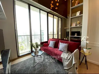 Stylish living room with floor-to-ceiling windows and modern decor in a high-rise apartment.