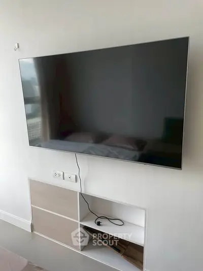 Modern living room with wall-mounted flat-screen TV and sleek storage unit.