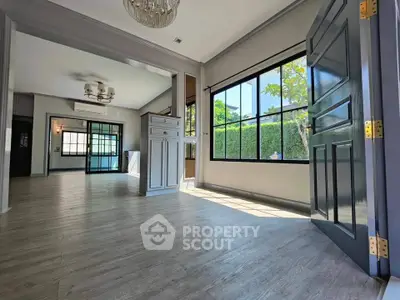 Spacious open-layout living room with large windows and elegant flooring