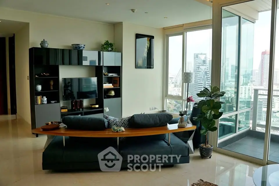 Luxurious living room with modern decor and stunning city view from large windows and balcony.