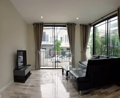 Spacious living room with modern decor and large windows offering natural light