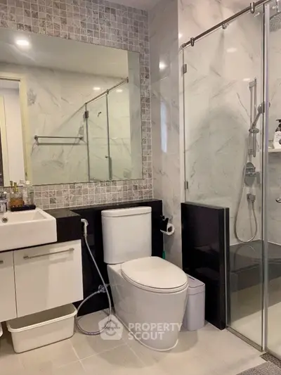 Modern bathroom with glass shower and sleek fixtures in luxury apartment
