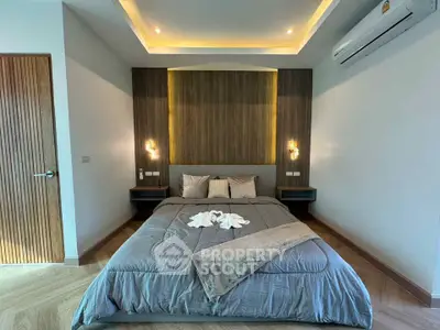 Modern bedroom with elegant lighting and cozy bedding in a stylish apartment.