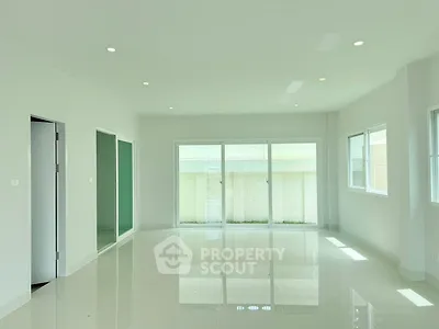 Spacious modern living room with large windows and glossy white flooring