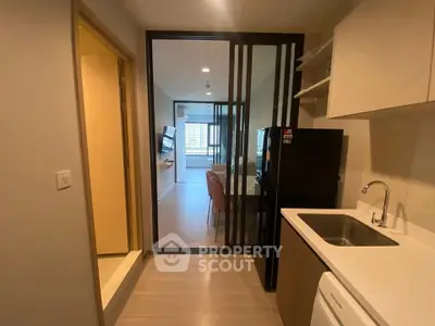 Modern apartment interior with open kitchen and living area, featuring sleek design and ample natural light.