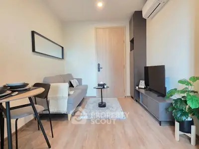 Modern living room with cozy sofa, TV unit, and stylish decor in a compact apartment.