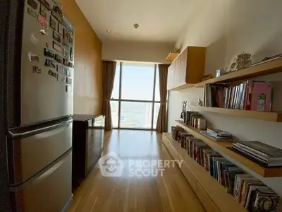 Spacious kitchen with wooden flooring and large window offering a stunning view.