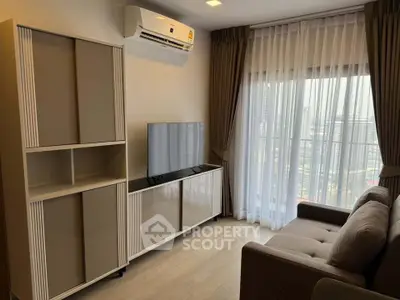 Modern living room with sleek furniture and large window offering city view