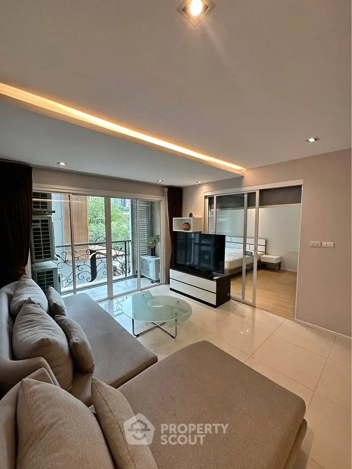 Modern living room with elegant sofa, glass coffee table, and balcony view in stylish apartment.