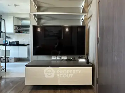 Modern living room with sleek TV setup and open kitchen layout, perfect for contemporary living.
