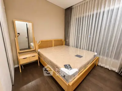 Modern bedroom with wooden furniture and large window with sheer curtains