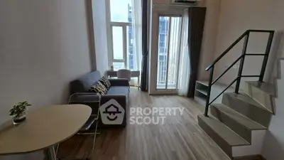 Modern loft-style living room with staircase and balcony view