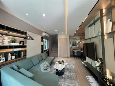 Stylish modern living room with sleek design and open layout, featuring a cozy green sofa and elegant decor.