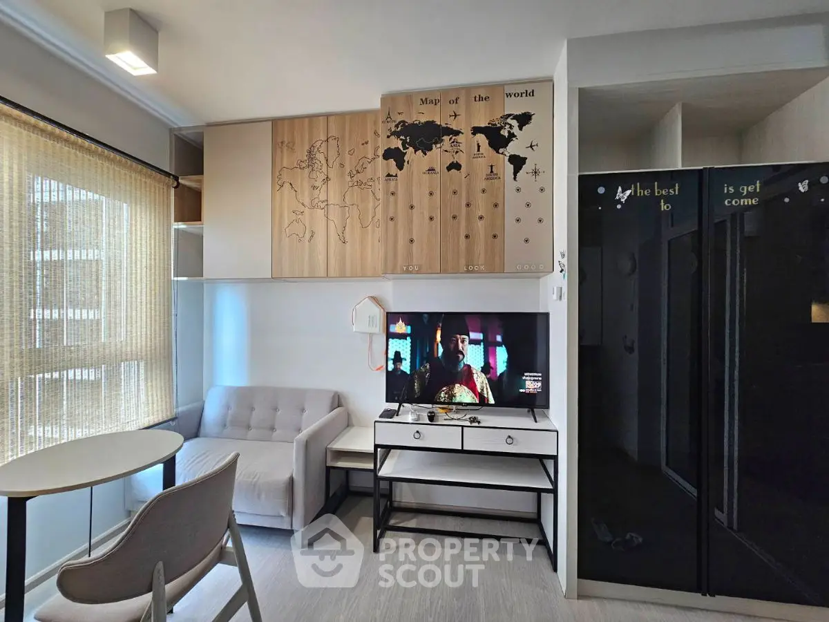 Modern living room with stylish decor and wall map, featuring a cozy sofa and TV setup.