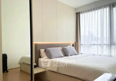 Modern bedroom with large window and stylish decor, perfect for relaxation and comfort.