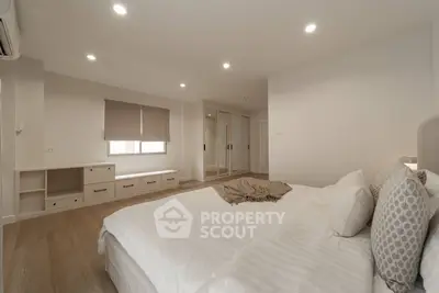 Spacious modern bedroom with elegant decor and ample natural light