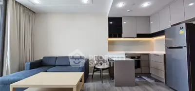 Modern open-layout living room with sleek kitchen and cozy seating area.