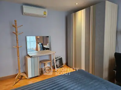 Modern bedroom with stylish wardrobe, cozy bed, and elegant vanity set in a well-lit space.