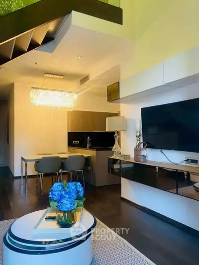 Modern living room with open kitchen, elegant chandelier, and stylish decor in a contemporary apartment.
