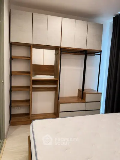 Modern bedroom with stylish wooden wardrobe and comfortable mattress