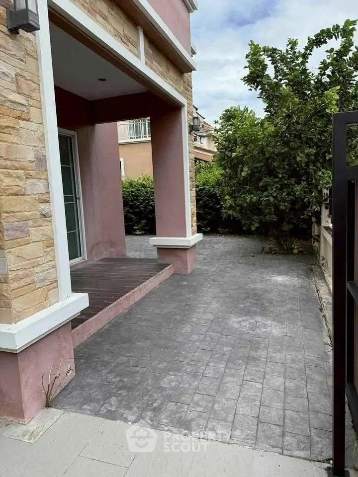 Charming exterior view of a modern home with stone accents and lush greenery.