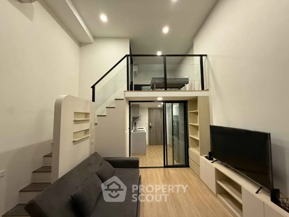 Modern loft-style living room with mezzanine, sleek design, and cozy ambiance.