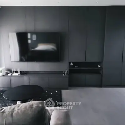 Modern living room with sleek black cabinetry and large flat-screen TV