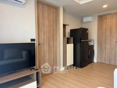 Modern living room with sleek appliances and wooden accents in a stylish apartment.