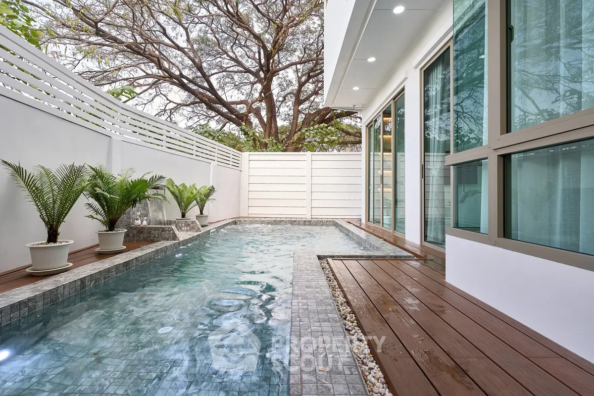 Luxurious private pool with modern design and lush greenery in a serene backyard setting.